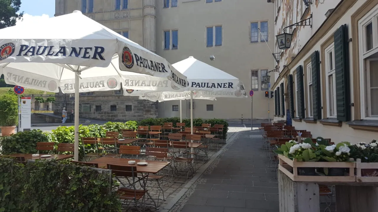 Sonniger Biergarten mit Paulaner-Sonnenschirmen in der Coburger Altstadt